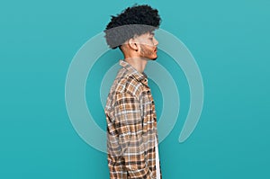 Young african american man with afro hair wearing casual clothes looking to side, relax profile pose with natural face with