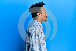 Young african american man with beard wearing casual clothes looking to side, relax profile pose with natural face with confident