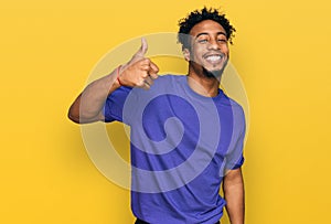 Young african american man with beard wearing casual purple t shirt doing happy thumbs up gesture with hand