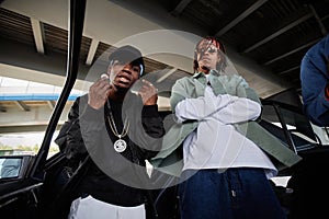 Young African American man in cap and black bomber jacket and his buddy