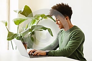 Young african american man developer working on laptop at cafe