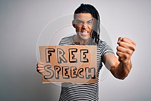 Young african american man with dreadlocks holding banner with free speech message protest annoyed and frustrated shouting with