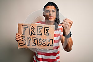 Young african american man with dreadlocks holding banner with free speech message protest annoyed and frustrated shouting with