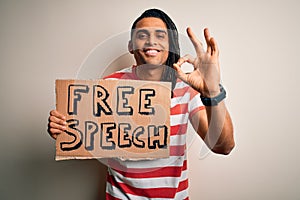 Young african american man with dreadlocks holding banner with free speech message protest doing ok sign with fingers, excellent