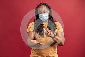 African American man in mask spraying sanitizer