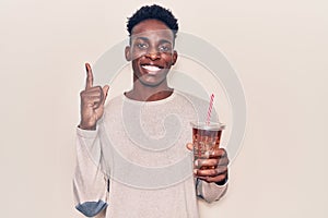 Young african american man drinking mate infusion smiling with an idea or question pointing finger with happy face, number one