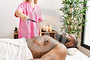 Young african american man having incense aromatherapy treatment at beauty center