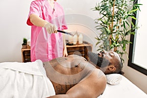 Young african american man having incense aromatherapy treatment at beauty center