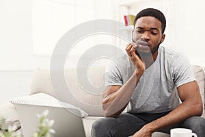Young african-american man having toothache at home