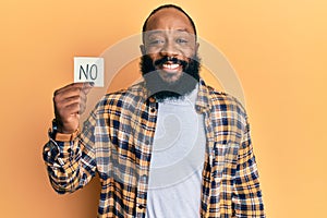 Young african american man holding no reminder looking positive and happy standing and smiling with a confident smile showing