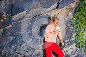 Young African American Man holding white flower, waiting for you