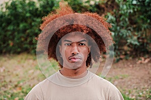 Young african american man looking serious at camera. Close up portrait of teenage male with pensive attitude. front