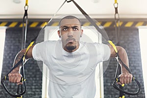 Man performing TRX suspension training in gym