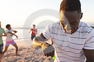 Young African American man prepares to blow bubbles on the beach