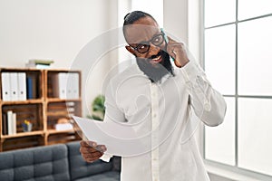 Young african american man psychologist talking on the smartphone at psychology center