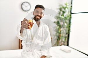 Young african american man relaxed smiling happy drinking champagne at beauty center