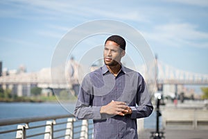 Young African American man with the river and bridge in the back