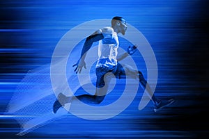 Young african-american man running isolated on blue studio background