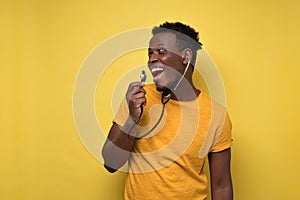 Young african american man singing on stethoscope listening his voices.