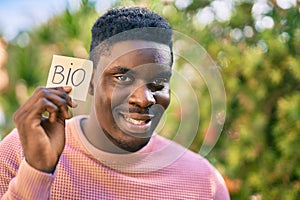 Young african american man smiling happy holding bio message reminder at the park