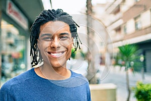 Young african american man smiling happy looking to the camera at street of city