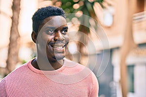 Young african american man smiling happy standing at the city