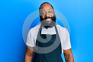 Young african american man tattoo artist wearing professional uniform and gloves with a happy and cool smile on face