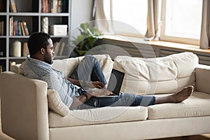 Young african american man using laptop lounge on sofa