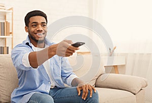 Young african-american man watching TV at home