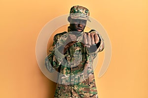 Young african american man wearing army uniform punching fist to fight, aggressive and angry attack, threat and violence