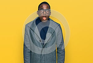 Young african american man wearing business clothes and glasses afraid and shocked with surprise and amazed expression, fear and