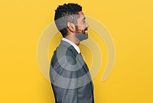 Young african american man wearing business clothes looking to side, relax profile pose with natural face with confident smile