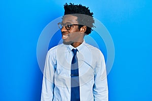 Young african american man wearing business clothes looking to side, relax profile pose with natural face and confident smile