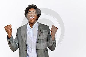 Young african american man wearing business jacket over isolated white background very happy and excited doing winner gesture with