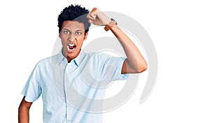 Young african american man wearing casual clothes angry and mad raising fist frustrated and furious while shouting with anger