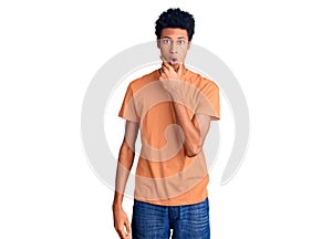 Young african american man wearing casual clothes looking fascinated with disbelief, surprise and amazed expression with hands on