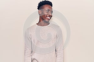 Young african american man wearing casual clothes looking to side, relax profile pose with natural face and confident smile