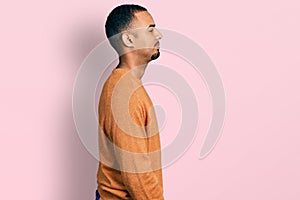 Young african american man wearing casual clothes looking to side, relax profile pose with natural face and confident smile