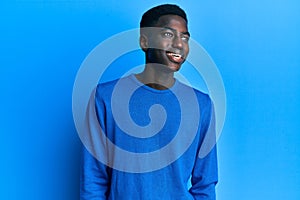 Young african american man wearing casual clothes looking to side, relax profile pose with natural face and confident smile