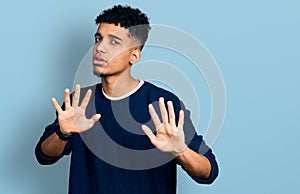 Young african american man wearing casual clothes moving away hands palms showing refusal and denial with afraid and disgusting