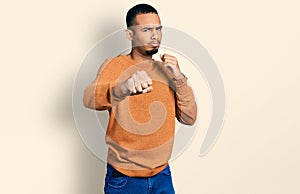 Young african american man wearing casual clothes punching fist to fight, aggressive and angry attack, threat and violence