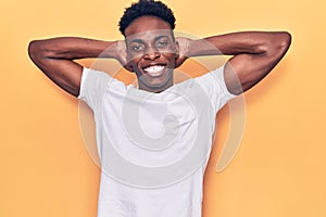 Young african american man wearing casual clothes relaxing and stretching, arms and hands behind head and neck smiling happy