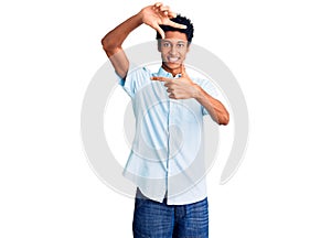 Young african american man wearing casual clothes smiling making frame with hands and fingers with happy face