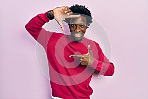 Young african american man wearing casual clothes smiling making frame with hands and fingers with happy face