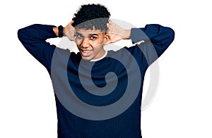 Young african american man wearing casual clothes trying to hear both hands on ear gesture, curious for gossip