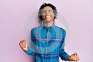 Young african american man wearing casual clothes very happy and excited doing winner gesture with arms raised, smiling and