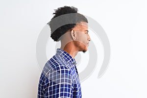 Young african american man wearing casual shirt standing over isolated white background looking to side, relax profile pose with