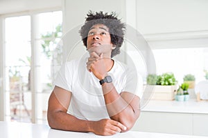 Young african american man wearing casual white t-shirt sitting at home Thinking worried about a question, concerned and nervous