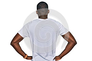 Young african american man wearing casual white t shirt standing backwards looking away with arms on body