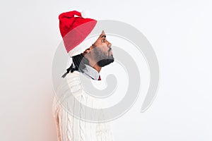 Young african american man wearing Christmas Santa hat over isolated white background looking to side, relax profile pose with
